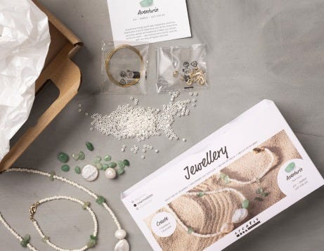 Kits de bricolage de bijoux ouverts et contenu affiché sur une table