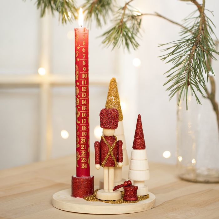 Un bougeoir décoré d’une figurine de Casse-Noisette, de sapins de Noël et de mini perles de verre.