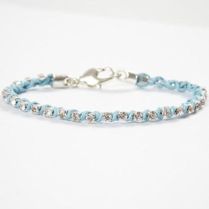 Un bracelet fait avec une chaîne de perles de strass et une corde de coton