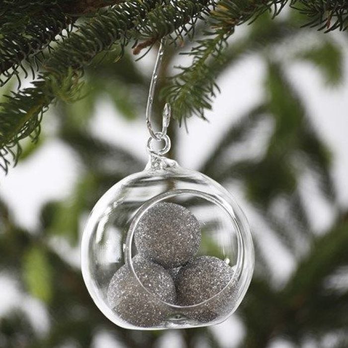 Boule en verre remplie par billes brillantes argentées