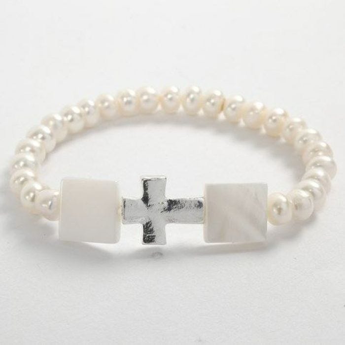 Un bracelet élastique avec des perles blanches et une croix