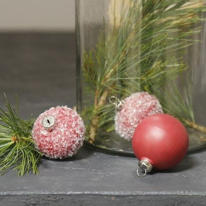 Des boules en terre cuite, peintes et décorées avec des paillettes