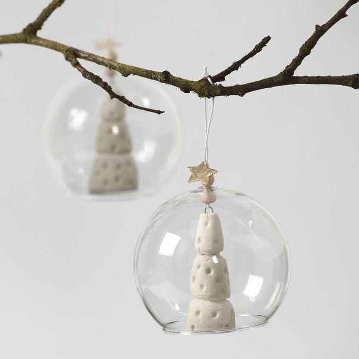 Un arbre de Noël d'argile blanche à l'intérieur d'une boule de verre