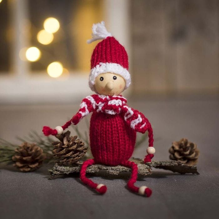 An elf knitted from acrylic yarn with wooden beads for hands and feet