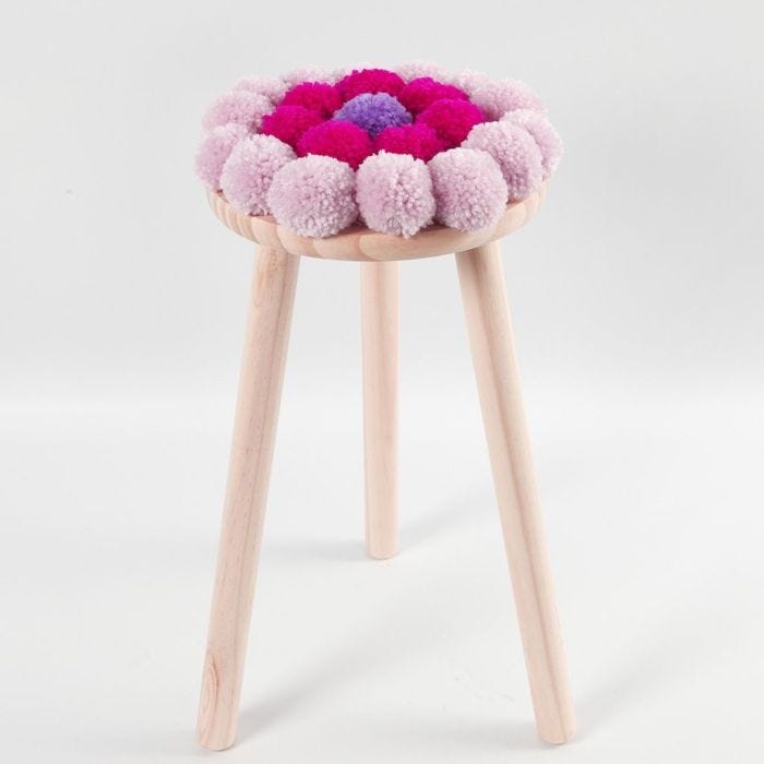 Un coussin pour chaise décoré de pompons