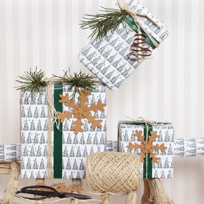 Kerstcadeaus inpakken met cadeaupapier met kerstbomen