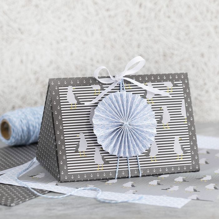 A dark blue Gift Box decorated with a blue Rosette and Design Paper