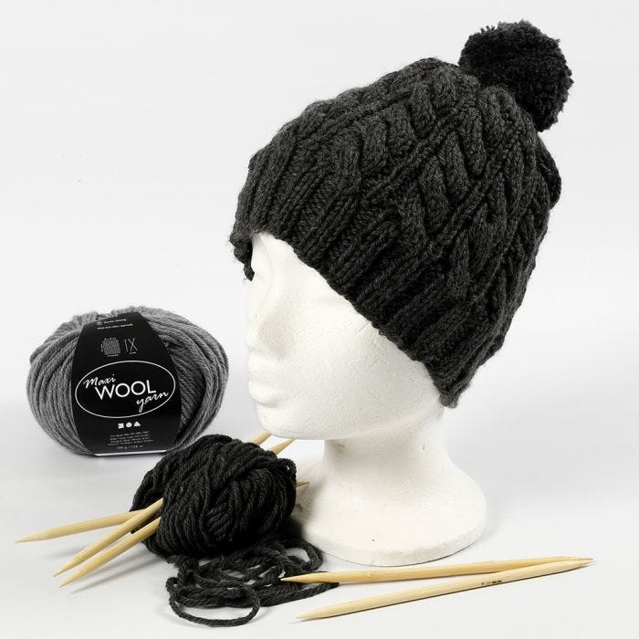 A hat knitted with a twist cable pattern and a pom-pom