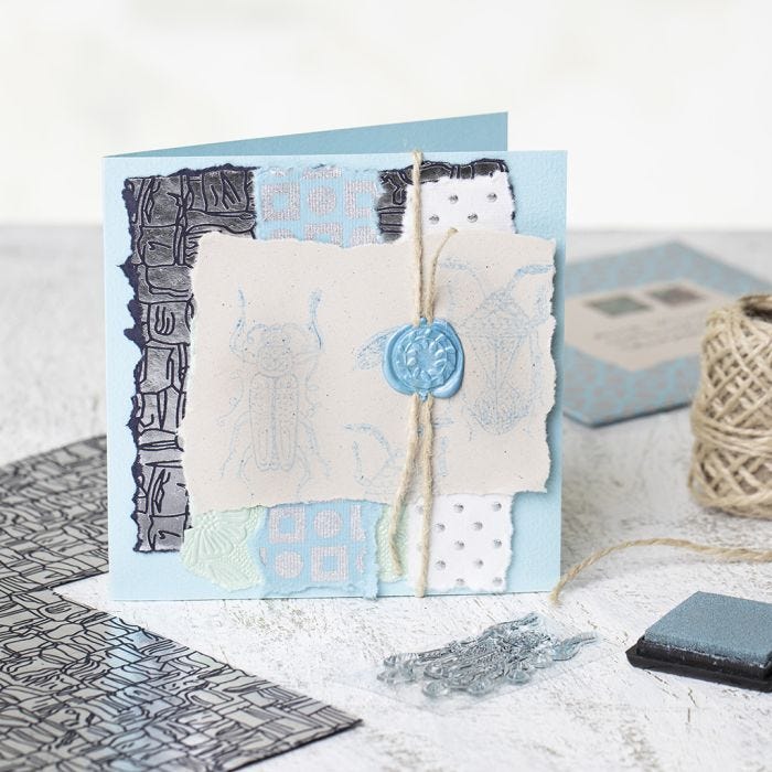 A homemade Greeting Card with handmade Paper, stamped Designs and a waxed Seal