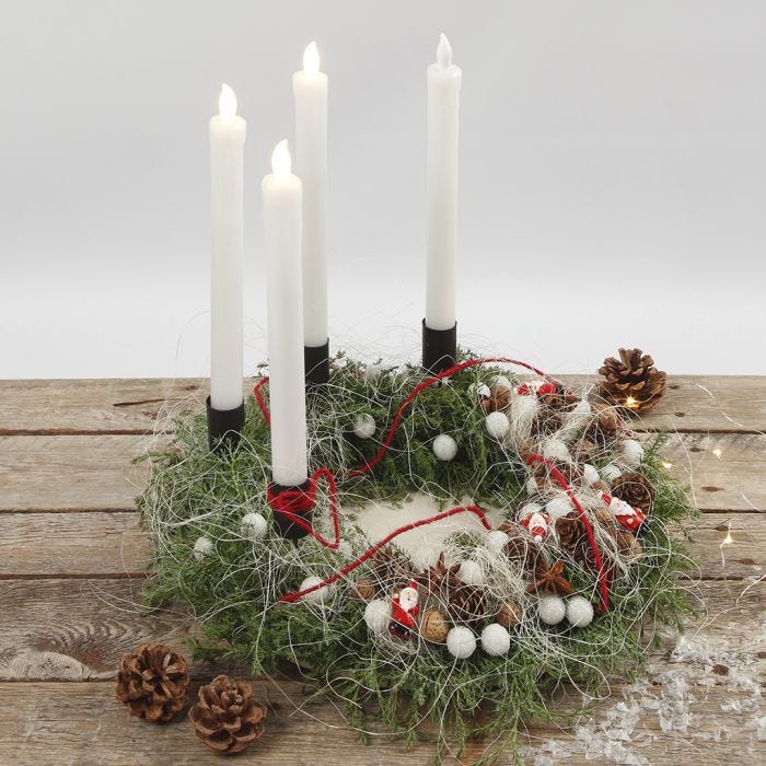 An Advent wreath decorated with natural materials and LED candles