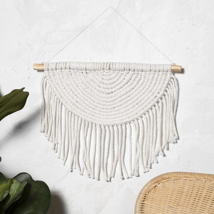 A  macramé wall hanging braided in a semi circle