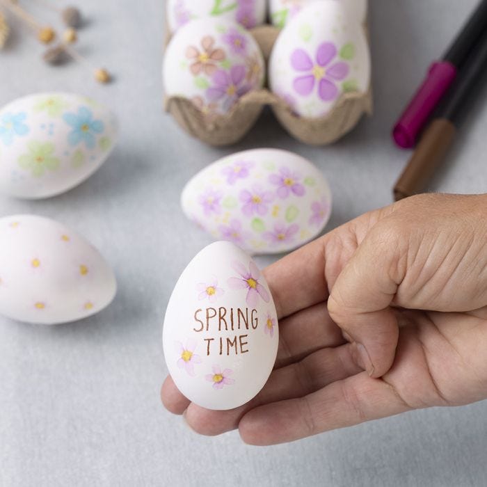 Des fleurs à l'aquarelle sur des oeufs en plastique