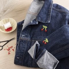 Bead-embroidered cherries on a jeans jacket