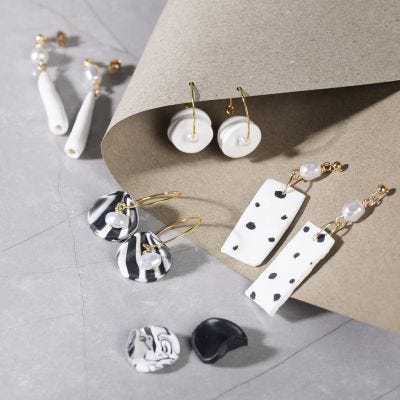 Boucles d’oreilles faites avec de la pâte à modeler pour bijoux et des perles blanches nacrées