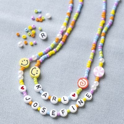 Un collier de perles avec des lettres, des figurines et des smileys