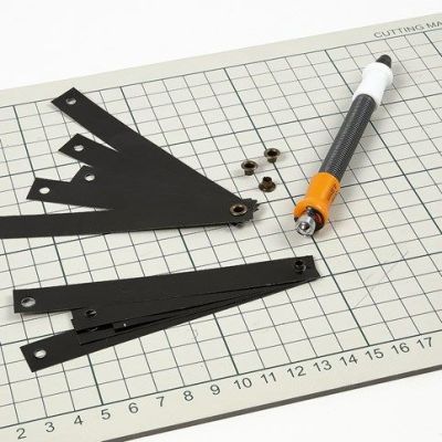 Des décorations à suspendre faites avec des bandes de papier étoiles noires dans des œillets avec un cordon de cuir