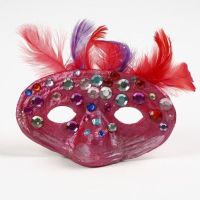 Un masque en papier mâché avec plumes et pierres de strass