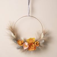 An autumn wreath with crepe paper flowers and pampas grass